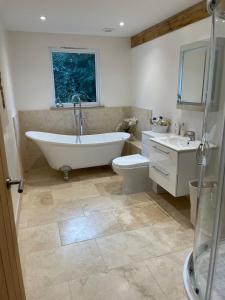 a bathroom with a tub and a toilet and a sink at Holly Barn in Worcester