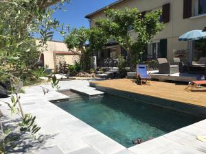 a swimming pool with a deck and a house at Chez-Sixtine Chambres d'Hôtes in Albon