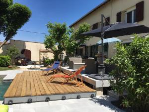 two chairs and an umbrella sitting on a wooden deck at Chez-Sixtine Chambres d'Hôtes in Albon