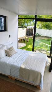 a bedroom with a large bed and a large window at Cabaña el Pilar in Fusagasuga
