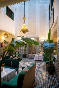 a lobby with couches and plants and a chandelier at Riad YAMNA - Quiet Desire in Fez