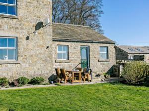 a table and chairs in front of a stone house at 2 Bed in Harrogate oc-hh018 in Lindley