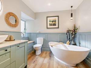a bathroom with a white tub and a toilet at 3 Bed in Settle oc-92466 in Settle +17 photos