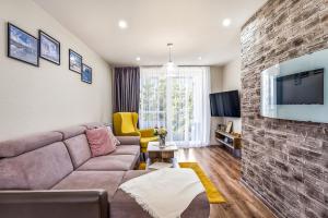 a living room with a couch and a brick wall at Apartmán Zara in Telgárt