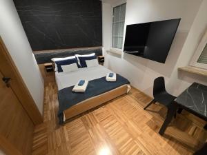 a bedroom with a bed and a flat screen tv at Apartmaji Sonce in Piran