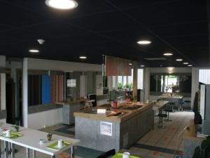 a kitchen with tables and counters in a building at ibis Budget Thiers in Thiers