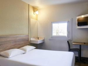 a bedroom with a bed and a sink and a window at hotelF1 Paris Saint Denis Stade in Saint-Denis