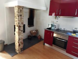 a kitchen with a pillar in the middle of a room at Quinta da Preciosa in Nebrijo