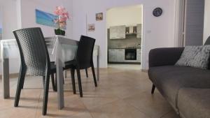 a dining table and chairs in a living room at D&M House Salento in Nardò