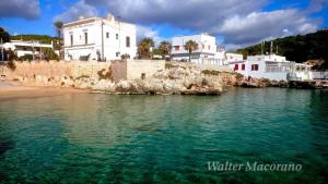 a group of white buildings on the shore of a body of water at D&M House Salento in Nardò