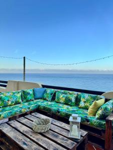 a couch sitting on a table next to the ocean at KAZA Aouchtame 2 in Laʼzîb