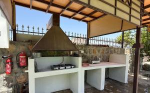 an outdoor kitchen with a stove and a hood at The Wadi Inn in Al Ḩamrāʼ