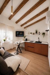 a kitchen with a couch and a table in a room at Una Baita nel Centro di Pescara con Parcheggio Privato - Palazzo Carolina in Pescara