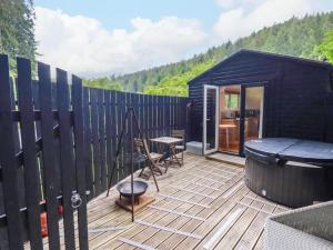 a black tiny house with a wooden deck at Foxglove cabin in Bodmin