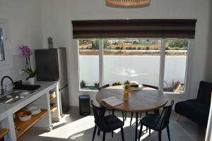 a kitchen with a table and chairs and a window at Thronos in Vlychada