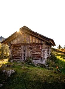 an old log cabin with the sun shining on it at Ferienhaus Ströbl in Liesing
