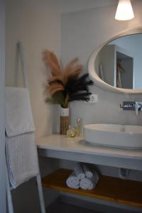 a bathroom with a sink and a mirror and towels at Thronos in Vlychada