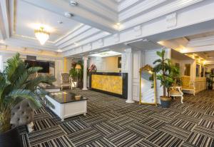 a lobby with a large screen tv and plants at Andalouse Otel in Trabzon