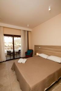 a bedroom with a large bed and a balcony at Vina Oliva Hotel in Pissouri