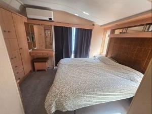 a small bedroom with a bed and a mirror at La cabane des fées in Yvoir