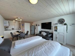 a bedroom with a bed and a living room at Allgäuauszeit mit Bergblick - Sauna - Balkon in Scheidegg