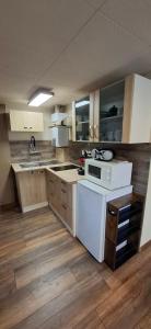 a kitchen with white appliances and wooden floors at Ferienhaus Roseneck Bad Tabarz in Tabarz