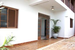 a white house with a potted plant in theoyer at Casa Alceste - Casa inteira, com garagem privativa, a 10 minutos a pé do Centro Histórico de Diamantina - 05 hóspedes in Diamantina