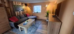 a living room with a couch and a table at Ferienhaus Roseneck Bad Tabarz in Tabarz