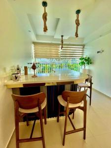 a kitchen with a bar with chairs and a table at Gladi Hidalgo in San Francisco de Macorís