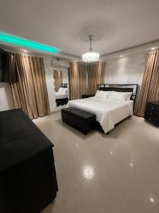 a bedroom with a large bed and a chandelier at Gladi Hidalgo in San Francisco de Macorís +18 photos