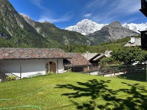 a house in a field with mountains in the background at La meison de Rita in Pré-Saint-Didier