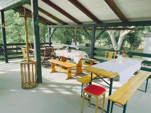 a pavilion with tables and chairs and benches at Zöldspalettás in Monor