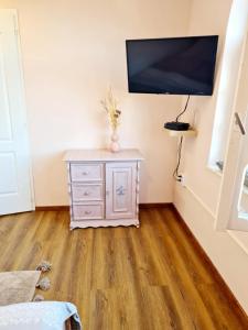 a room with a tv on a wall with a dresser at Zöldspalettás in Monor