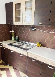 a kitchen with wooden cabinets and a sink at Zöldspalettás in Monor +15 photos