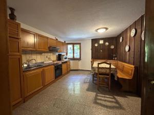a kitchen with wooden cabinets and a table in it at La meison de Rita in Pré-Saint-Didier