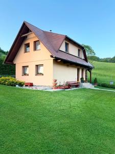 a house with a green lawn in front of it at Domček u Fera in Zázrivá
