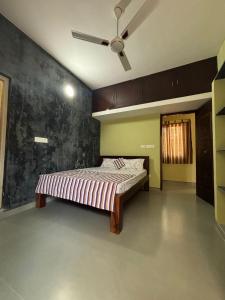 a bedroom with a bed and a ceiling fan at The Luxora Villa in Kuilapayam
