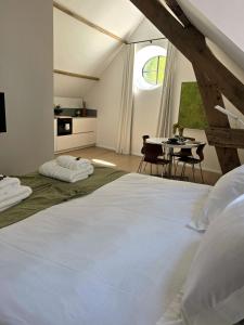 a bedroom with a large white bed and a table at Castle B&B Castanea in Merelbeke