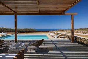 a swimming pool with chairs and a view of the ocean at Didimos Luxury Villas in Cherronisos