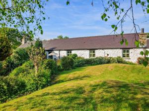 a stone house with a grassy hill in front of it at 2 Bed in Conwy oc-95905 in Conwy
