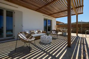 a patio with a couch and chairs on a deck at Didimos Luxury Villas in Cherronisos
