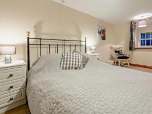 a bedroom with a large bed and a chair at 3 Bed in Bala oc-52810 in Llanuwchllyn