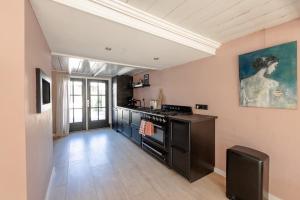 a kitchen with a stove and a painting on the wall at LITTLENEIGHBOUR in Pingjum +4 photos