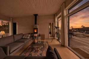 a living room with a couch and a large window at Seaside Escape - 10 Min to Ocean in Ytre Søndeled