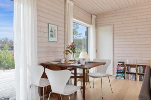 a dining room with a wooden table and white chairs at Seaside Escape - 10 Min to Ocean in Ytre Søndeled