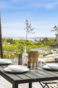 a wooden table with plates and glasses and a bottle at Seaside Escape - 10 Min to Ocean in Ytre Søndeled +46 photos