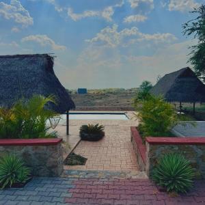 a resort with a swimming pool and a thatch roof at Loft acogedor cerca de Jardines de México in Vidalrstn