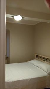 a bedroom with a white bed with a ceiling at La pergola in Sagliano Micca