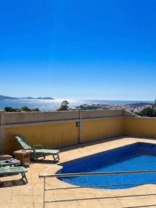 a swimming pool on a patio with a view of the ocean at La Pepa Sanxenxo in Sanxenxo