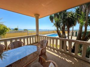 a balcony with a table and chairs and a pool at La Pepa Sanxenxo in Sanxenxo